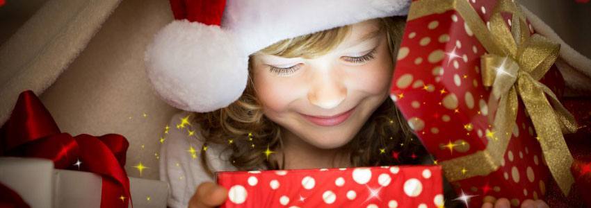 A child opening a christmas present under a blanket