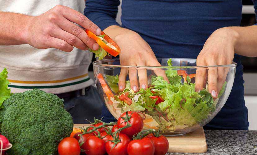 Fresh lettuce in a bowl with grape tomatoes and broccoli on the side