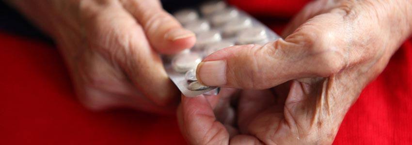 Elderly person takes pills