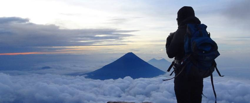 A person standing at the top on a mountain looking down