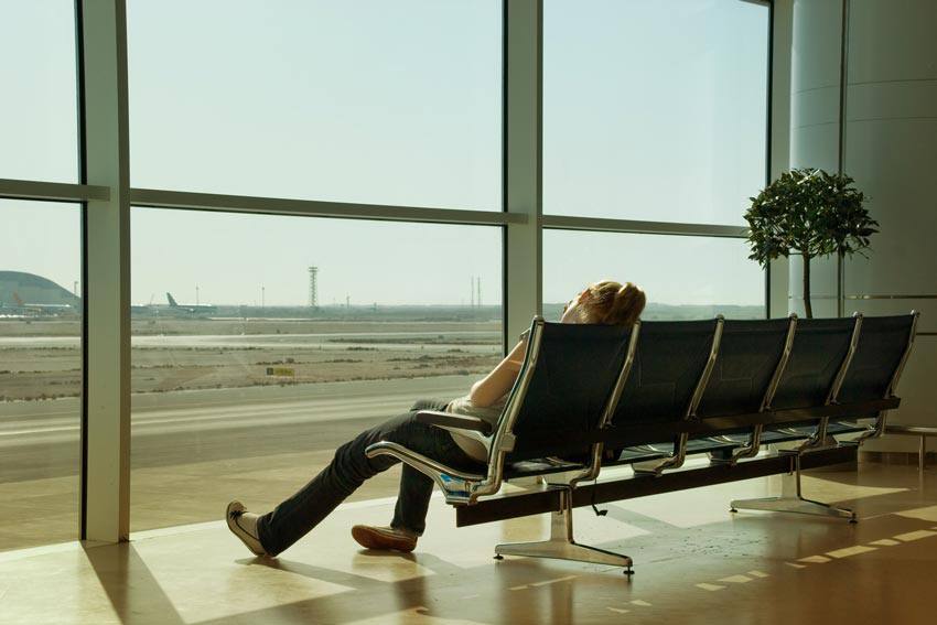 A woman sleeping on a chair at the airport