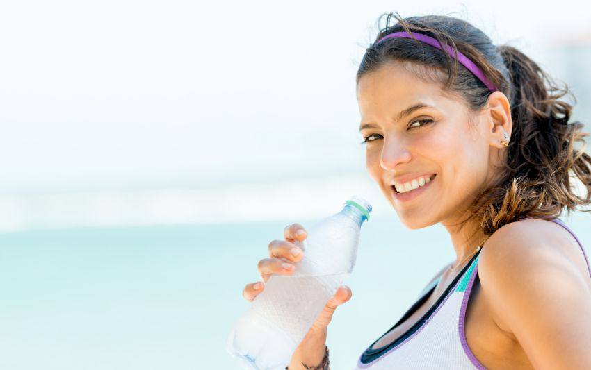 A woman drinking water after doing sports