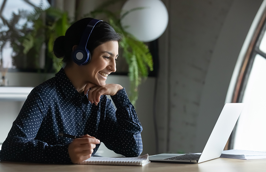 Woman smiling at computer screen