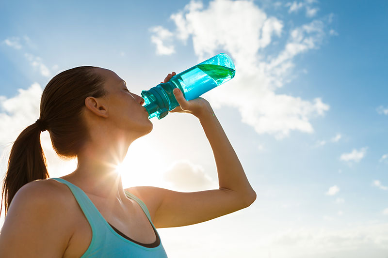 women drinking water under the sun