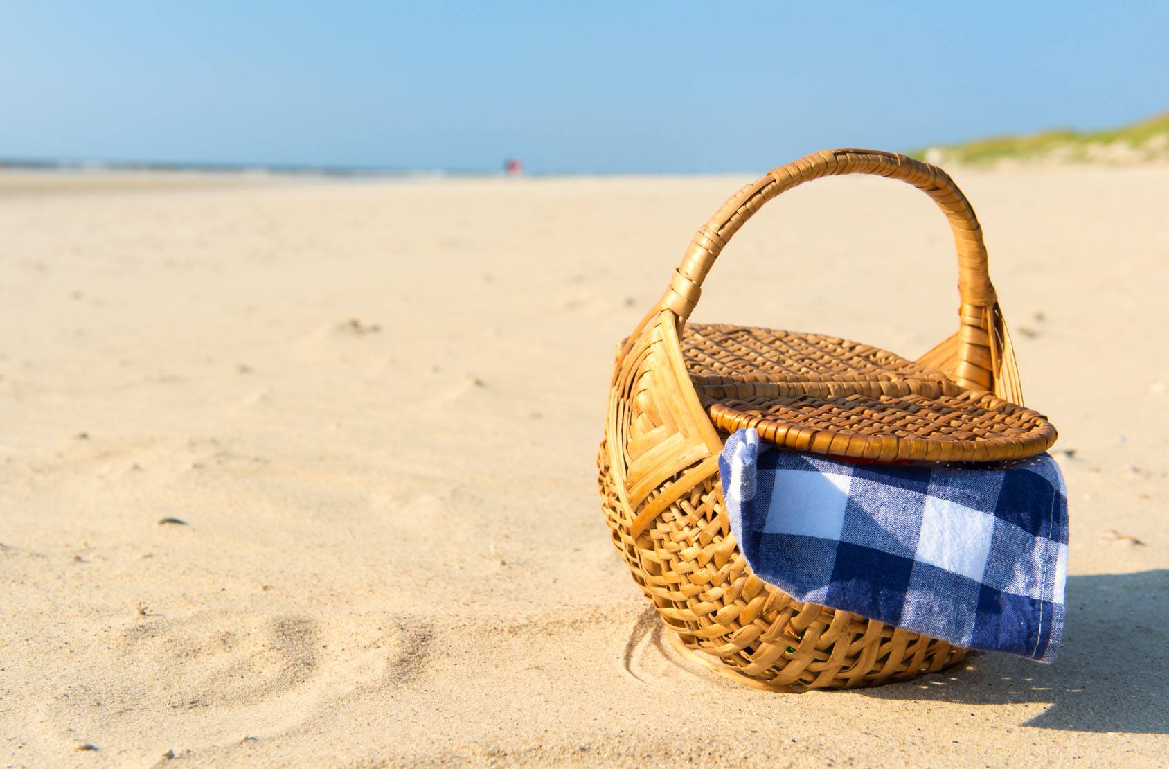 A picnic basket on the beach sand