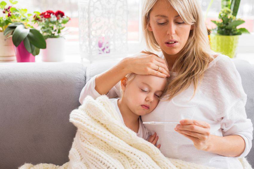 A mother looking at the temperature of her sick child