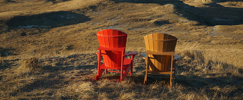 Two chairs all alone in a long field