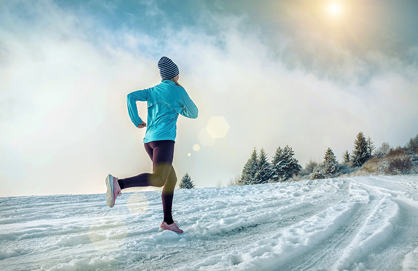 A lady runs in the snow in winter