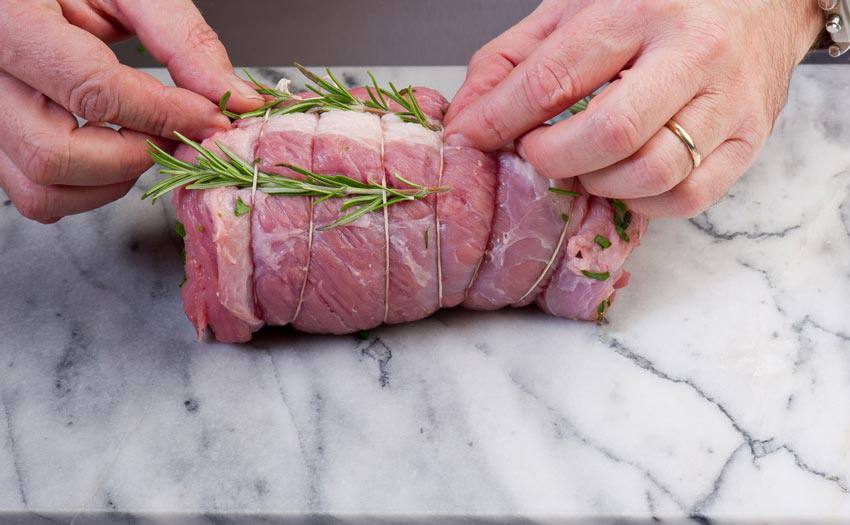 A piece of meat tied with rosemary leaves