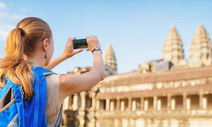 A lady takes a photo of a building