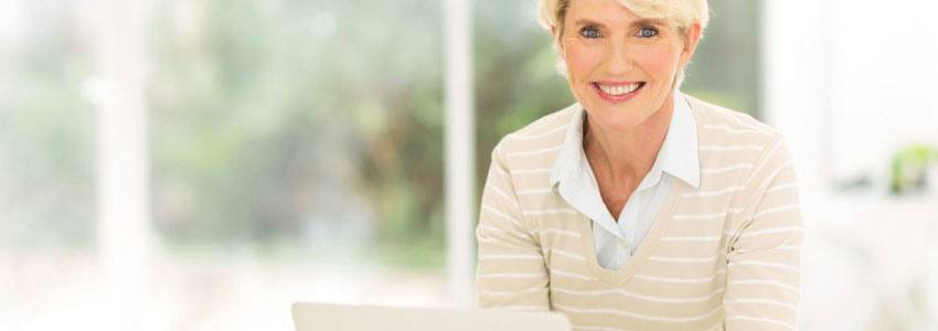 A woman smiling while using her laptop 