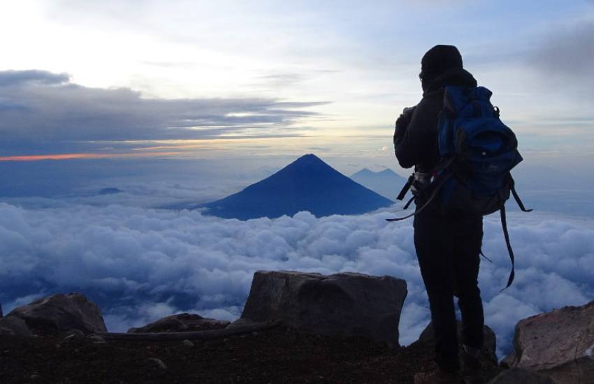 A person standing at the top on a mountain looking down