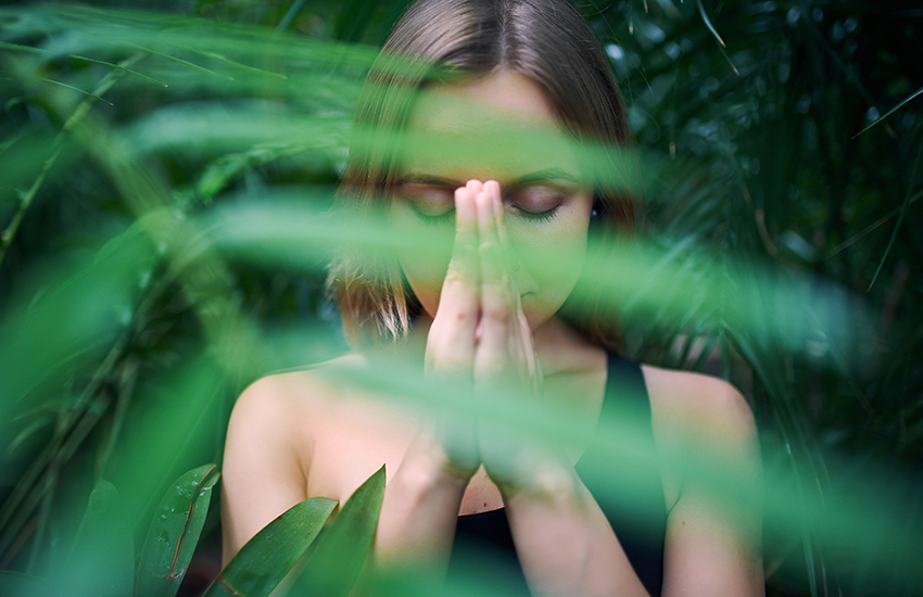 A woman praying in the forest alone