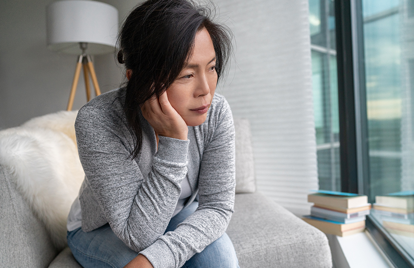 A sad woman sitting on the couch