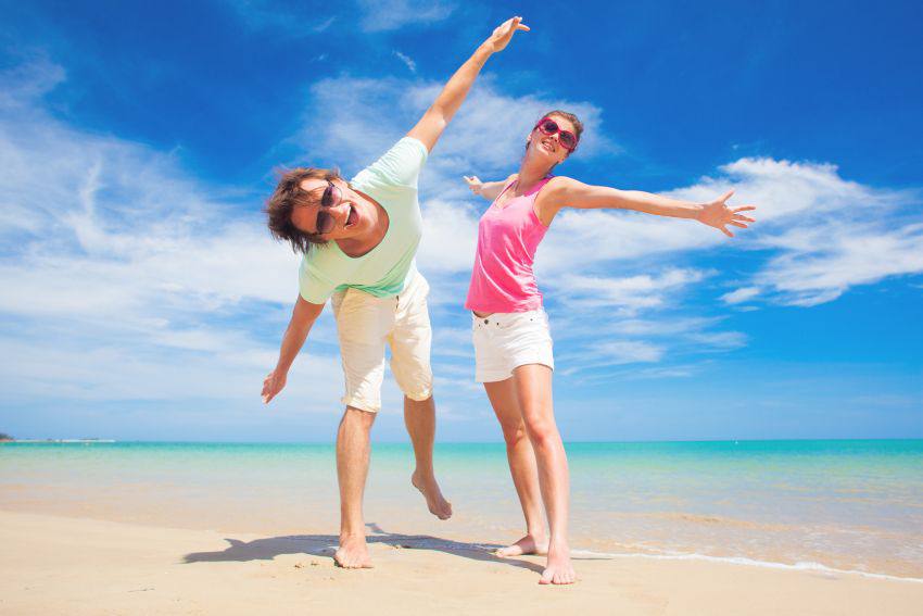 Two happy people on the edge of a beach