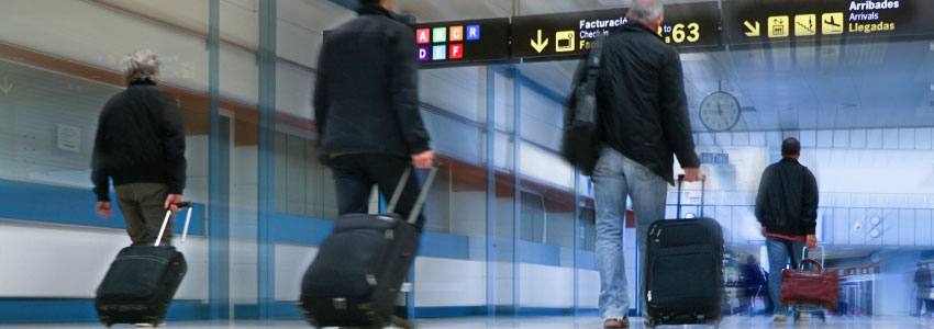 People walking in the airport with their luggage