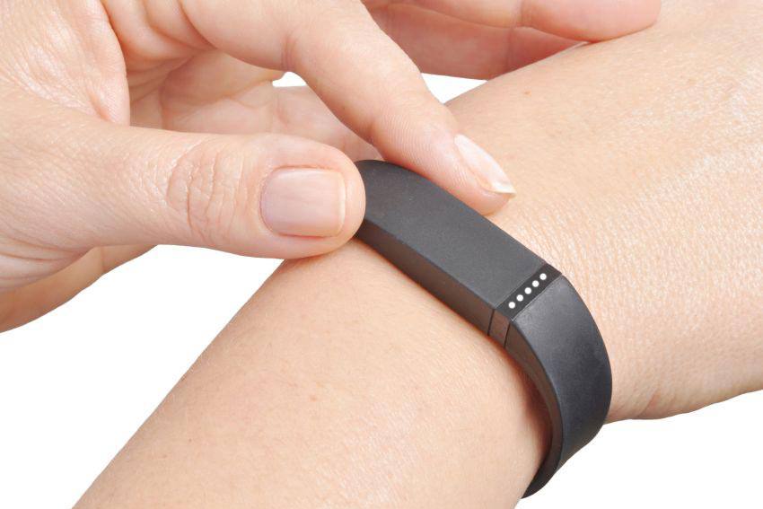 A person using their fitbit on their wrist