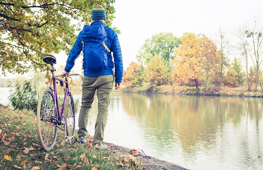 Biker standing next to river