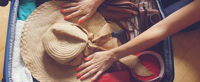 A suitcase full of clothes and a hat