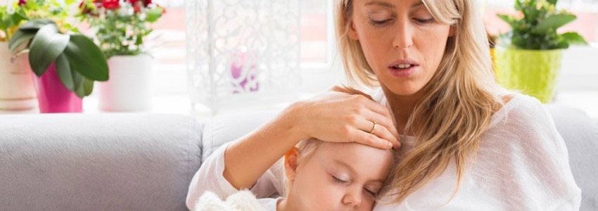 A mother looking at the temperature of her sick child