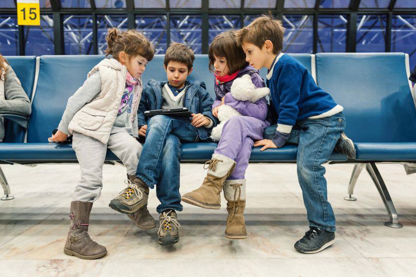 Three children sitting and watching an iPad