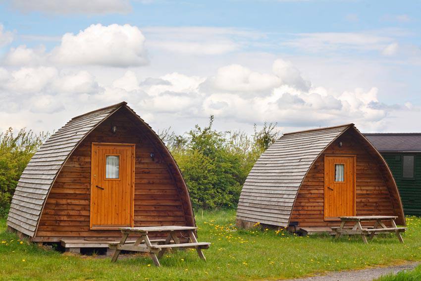 Two glamping tents with benches outside