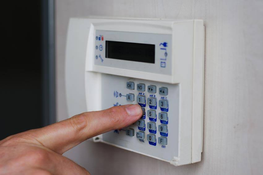 A person entering the code to an alarm in their house