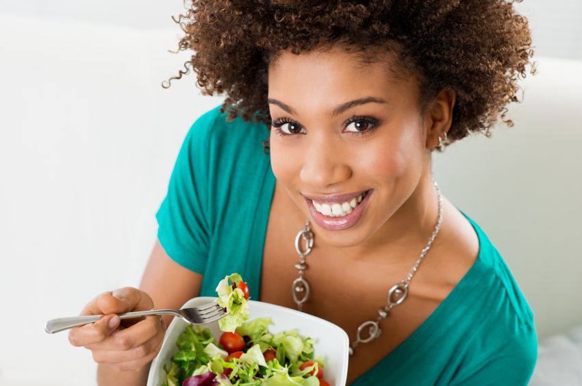 A happy person eating a good vegan meal