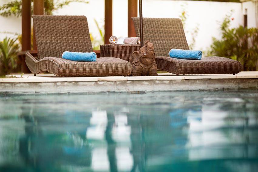 Comfortable chairs on the edge of a swimming pool