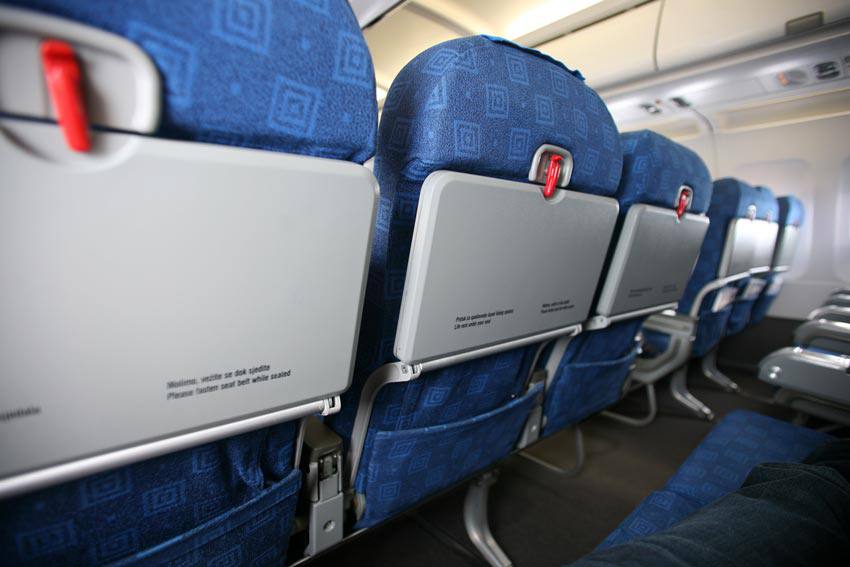 Two rows of three airplane seats in an airplane 