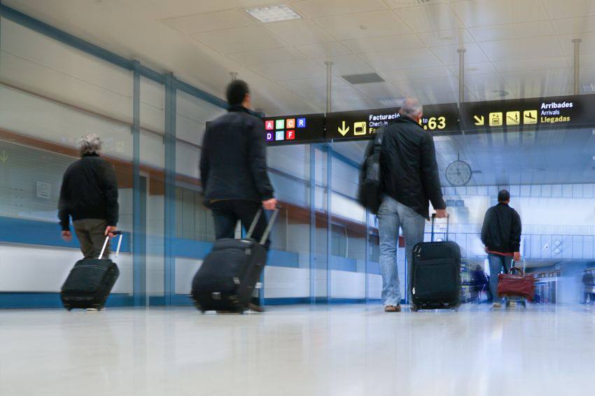 People walking in the airport with their luggage