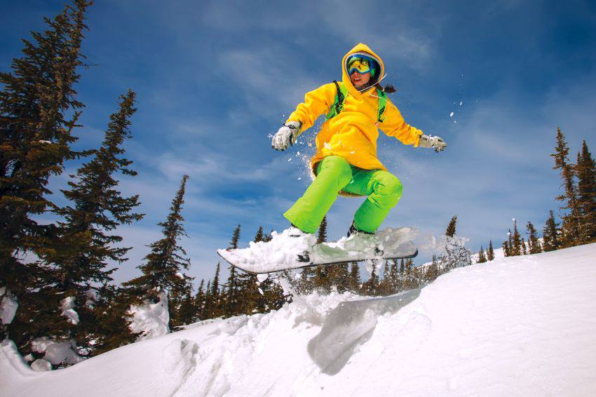 A person jumping whlie on a snowboard