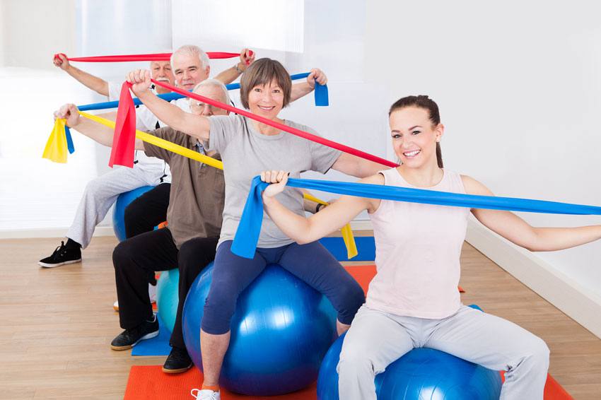 People with resistance bands sitting on fitness balls