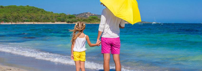 Two people hold hands on the beach