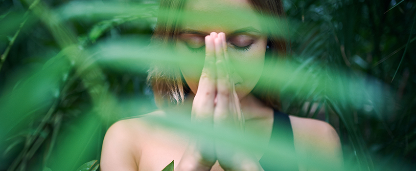 A woman praying in the forest alone