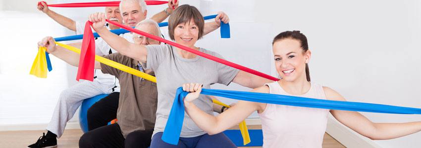 People with resistance bands sitting on fitness balls