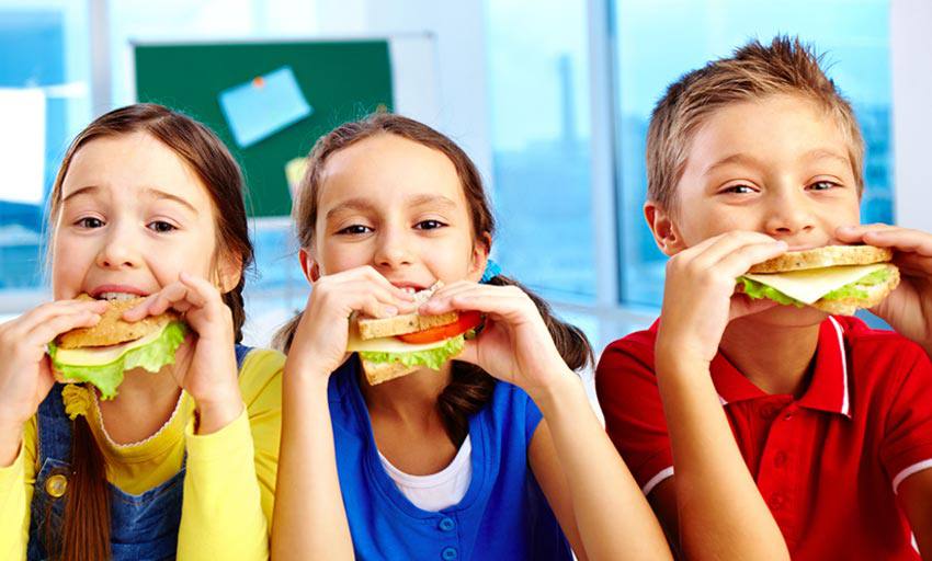 Three kids eating healthy sandwich