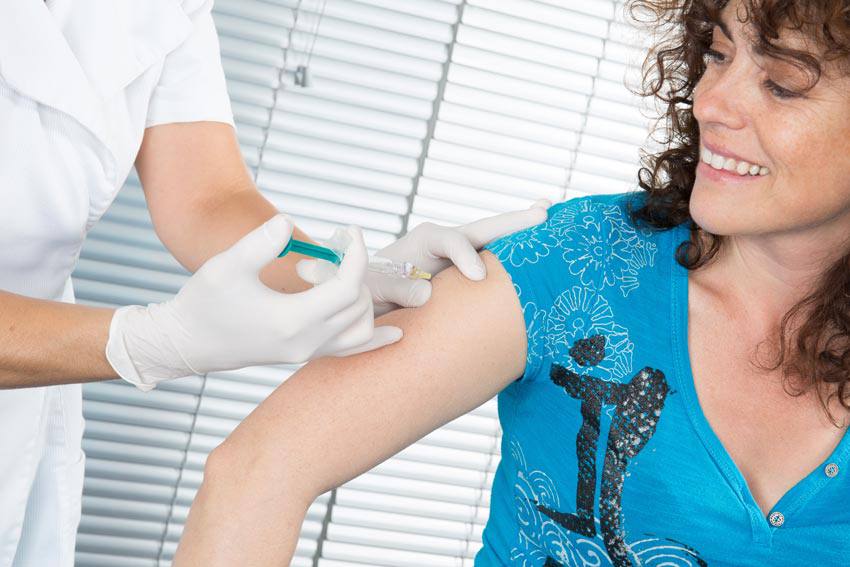 A woman getting a flu shot on her arm